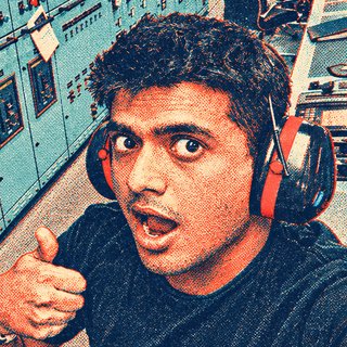 Harsh in ear defenders giving a thumbs-up in a ship's engine control room